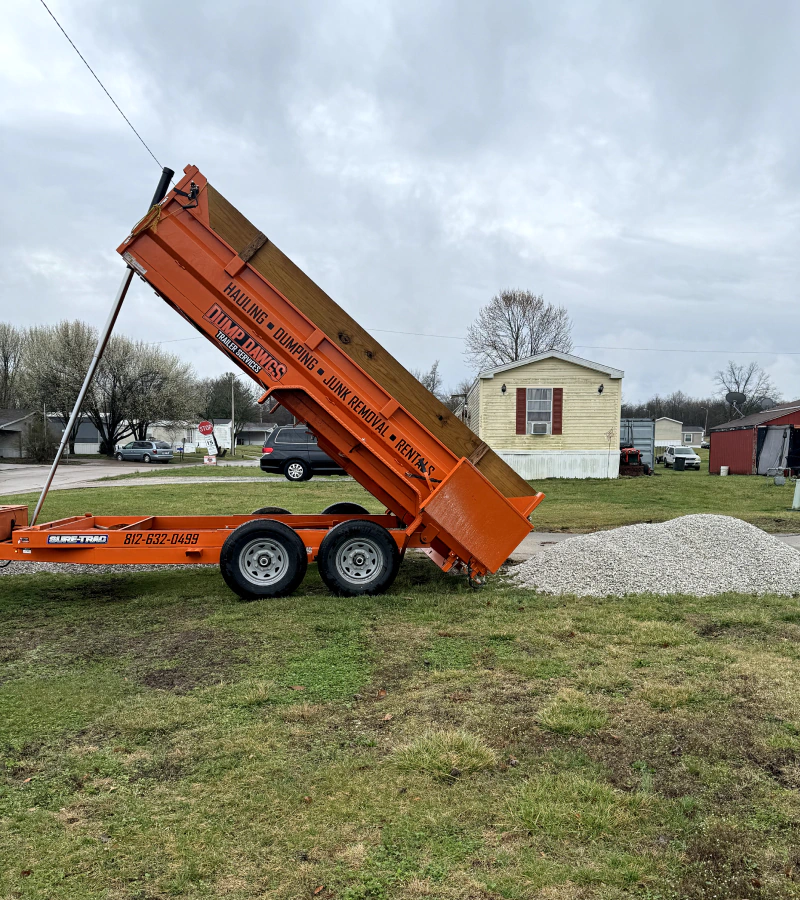 orange hauler dumping gravel onto land